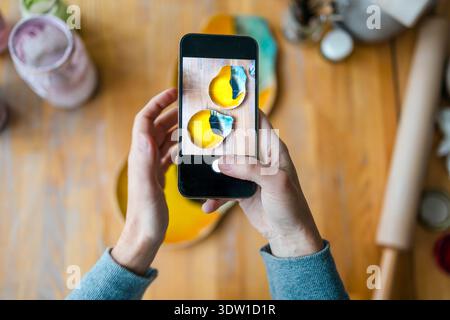 Hands of a woman photographing her products with a smartphone in a ceramics studio Stock Photo