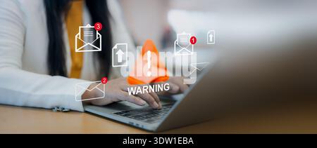 Email phishing warning icon overlay. Cybersecurity alert, Businesswoman using laptop with internet scam and fraud notification concept in modern offic Stock Photo