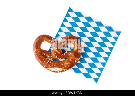 Traditional baked bavarian salty bread pretzel on paper serviette isolated on white background. German lye pastry bread. Top view card with copy space Stock Photo