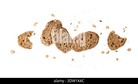 Slices of fresh baked multi grain baguette with poppy, sunflower, sesame seeds flying isolated on white background. Healthy pastry food Stock Photo