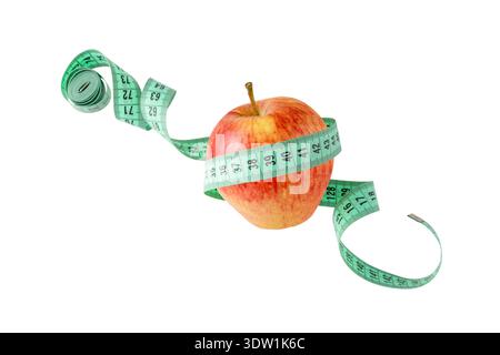 Red yellow apple and measuring tape flying isolated on white background. Symbol of healthy dieting and control body weight. Stock Photo