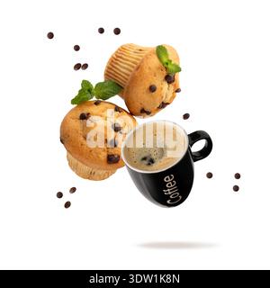 Fresh baked chocolate chips muffin with mint leaves and black cup hot espresso coffee flying isolated on white background. Two muffins in paper form a Stock Photo