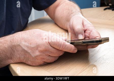 An elderly person using a smart phone and new technology. Stock Photo