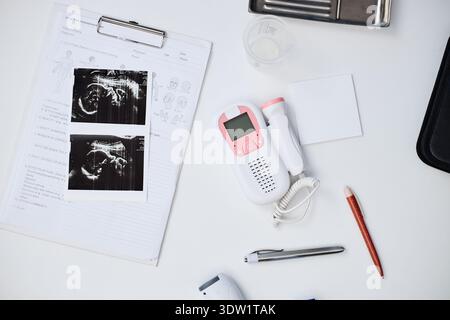 Fetal Ultrasound Images and Doppler Device Lying on Medical Examination Table Stock Photo