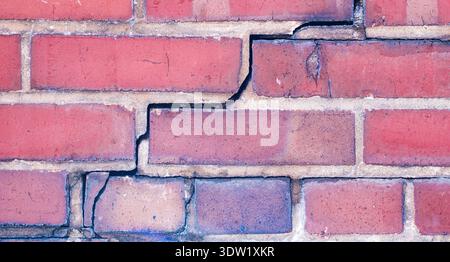 Brick wall damage for home inspection report. Structural crack in residential brick exterior. Brick background with visible settlement crack. Diagonal Stock Photo