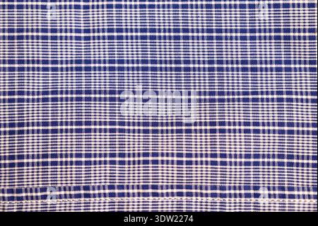 Full frame close-up of blue and white plaid fabric texture. Classic checkered textile pattern with intersecting stripe and woven detail. Stock Photo