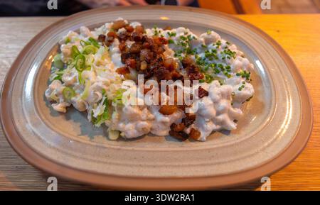 Plate of traditional Slovak Bryndzove Halusky, potato dumplings with bryndza cheese, bacon, and chives, served in Bratislava, Slovakia. Stock Photo