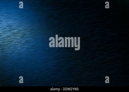 A deep blue abstract background features subtle diagonal lines and a soft gradient from light to dark, creating a sense of movement and depth Stock Photo