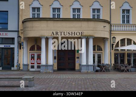 Entrance area of the historic Artushof at the Old Market in Stralsund featuring classical columns, arched portal and outdoor dining Stock Photo