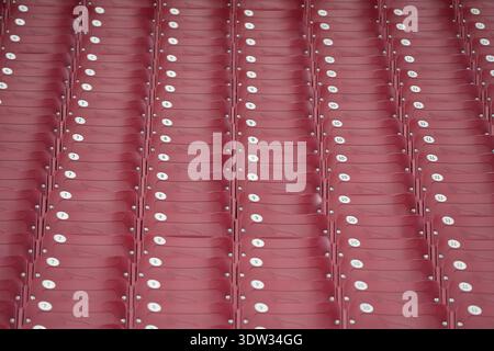Rows of seats, each with a white numbered label, are tightly arranged in a grid pattern. The seats are part of a large, organized seating area Stock Photo