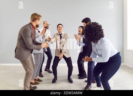 Happy man company employee having fun and dancing in office, celebrating success or making a deal. Stock Photo