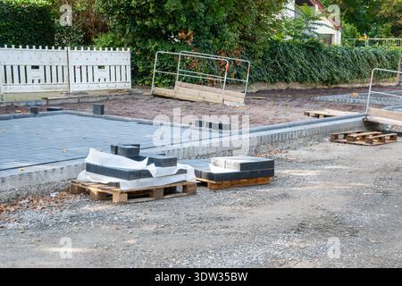 Pavement tiles for road sidewalk repair near houses. Construction process and urban infrastructure in big city. Stock Photo