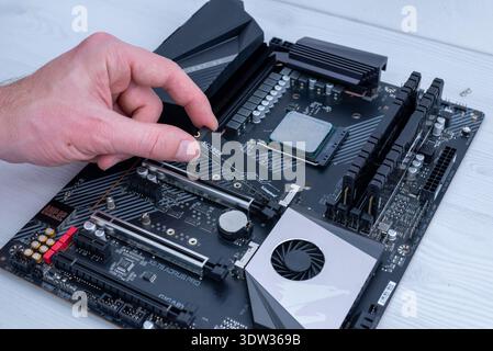Sarajevo, Bosnia and Herzegovina – February 13, 2026: Kingston kc3000 nvme m2 ssd being installed on gigabyte aorus motherboard during desktop pc asse Stock Photo