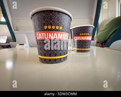 VALENCIA, SPAIN - APRIL 6, 2025: two Catunambu paper coffee cups on a table inside a passenger train in Valencia, Spain, showing Spanish coffee roaste Stock Photo