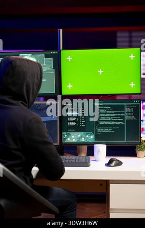 Hacker using green screen PC to gain unauthorized network access, targeting unpatched connections. Man using mockup computer to bypass security and exploit servers for stolen data profit Stock Photo