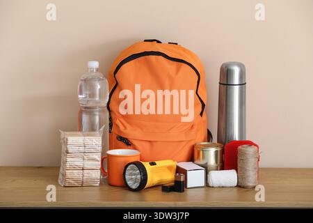 Emergency backpack and necessities on table at home Stock Photo
