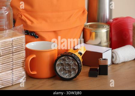 Emergency backpack and necessities on table at home Stock Photo