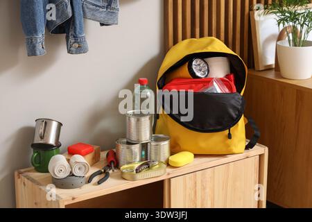Emergency backpack with necessities on shelf in hallway Stock Photo