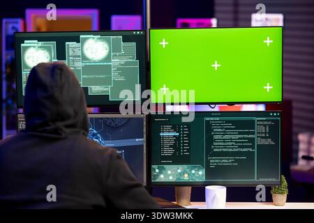 Hacker doing phishing attacks using green screen PC, tricking users into revealing credit card data. Man launching DDoS attacks with mockup computer, flooding servers to crash websites Stock Photo