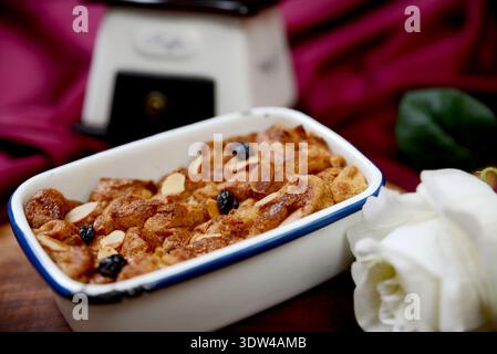 Traditional baked bread pudding with raisins and almonds in a ceramic dish Stock Photo
