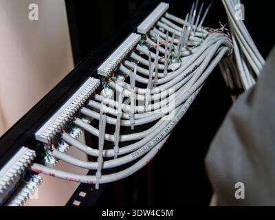 Technician hands installing network cables in server rack Stock Photo