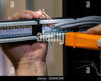 Technician hands installing network cables in server rack Stock Photo