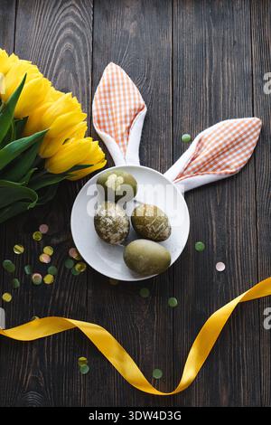 Easter flat lay composition with yellow tulips, natural dyed Easter eggs Stock Photo