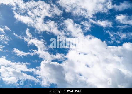 Blue Sky with Fluffy White Clouds on a Sunny Day, Perfect for Backgrounds and Overlays Stock Photo