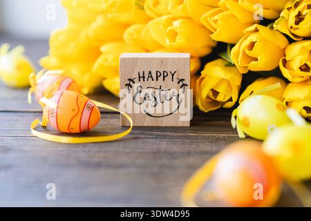 Spring festive composition with yellow tulips and decorative eggs Stock Photo