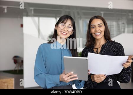 Two happy young businesswomen standing together for portrait Stock Photo