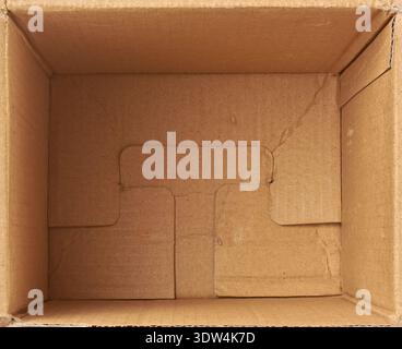inside of empty brown corrugated cardboard box, matte inner flap and folded bottom of open container mock-up template in top view, packaging Stock Photo