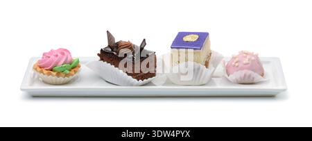 Four different mini cakes on ceramic plate isolated on white Stock Photo