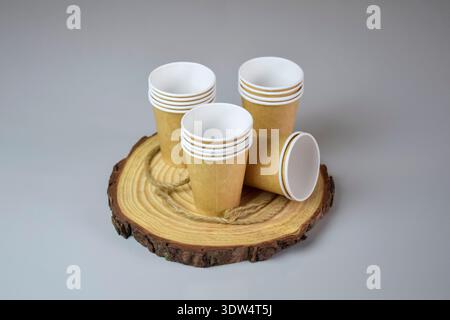 Blank brown takeaway coffee cups on gray background, mockup, template. Paper disposable cups on wooden cut. Copy space. Close-up. Stock Photo