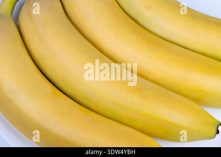 Bananas breakfast setup. Colorful ripe bananas displayed for nourishing breakfast. Brightly lit bananas arranged to inspire wholesome morning meal Stock Photo