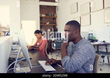 Research, business and man with thinking at computer for story angle, headline idea or editing article. Media agency, journalist or thoughtful with PC Stock Photo