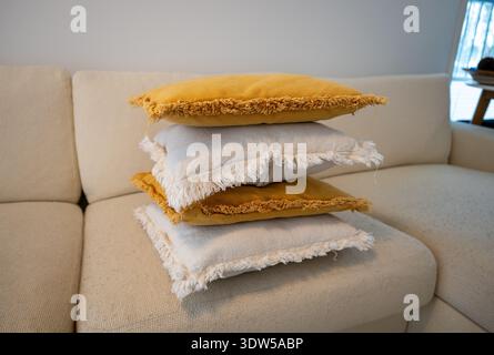 Stack of decorative pillows on sofa in cozy Scandinavian living room Stock Photo