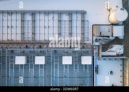 Drone view showing a large industrial data center building with server cooling infrastructure covered in snow, emphasizing technology and energy, Wars Stock Photo
