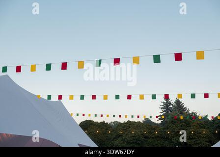 garland of fabric flags and light bulbs against a background of blue sky Stock Photo