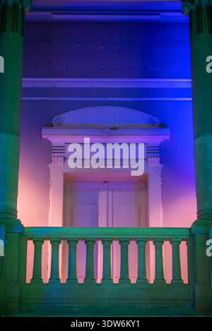 Neoclassical interior with a classical balustrade lit in purple and green light, Zagreb, Croatia Stock Photo