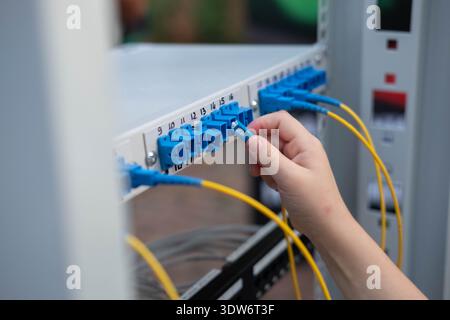 child's hand plugs the cable into the connector. Training stand at an exhibition of professions. Blur and selective focus Stock Photo