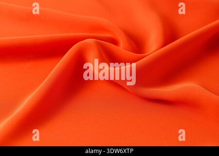 Abstract orange background. Silk fabric draped texture Stock Photo