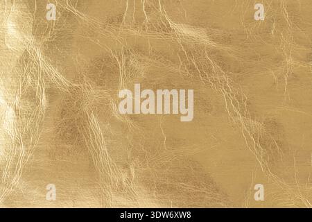 Cracked golden color foil leather texture as background with copy space Stock Photo