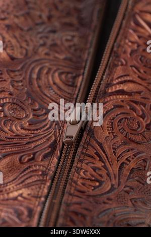Zipper on dark brown red leather with floral print. Detail of boot. Stock Photo