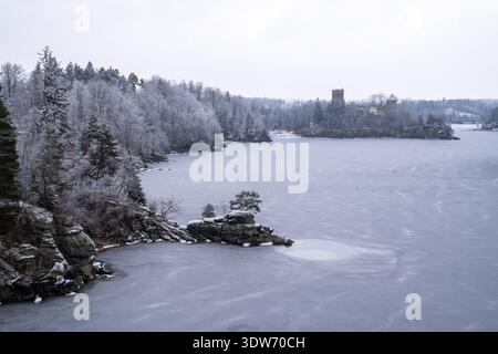 A striking winter view of the Ottensteiner Stausee reservoir in the Waldviertel region of Austria, completely frozen over. In the background, the medi Stock Photo