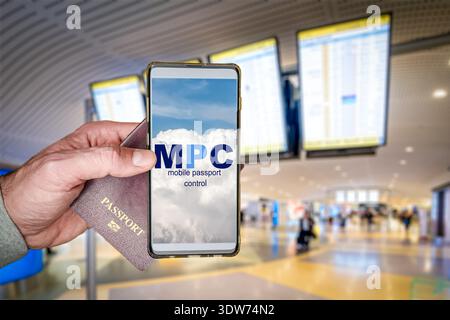 Traveler holding phone using Mobile Passport Control app at airport Stock Photo