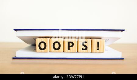 Oops symbol. Concept word Oops on beautiful wooden blocks in book. Beautiful wooden table white background. Business lifestyle oops concept. Copy spac Stock Photo