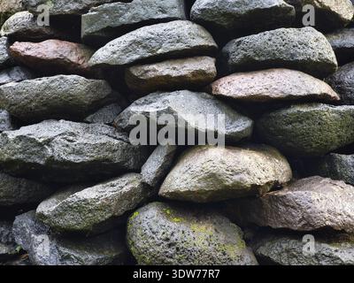 A pile of mossy river rocks in various shapes randomly Stock Photo