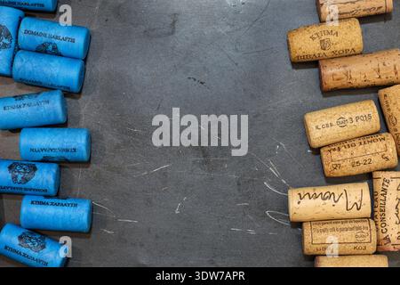 Athens, Greece - February 15, 2026: Top view of synthetic blue wine corks and natural cork stoppers featuring winery branding Stock Photo