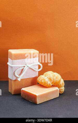 Handmade tangerine soap bars paired with fresh mandarin fruit in a bold studio setup, ideal for spa branding and organic beauty campaigns Stock Photo