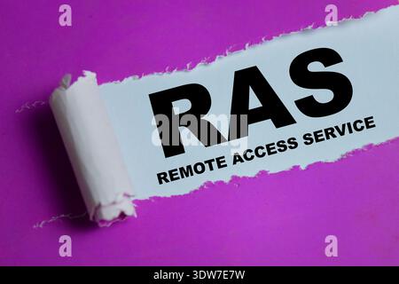 RAS - Remote Access Service text written in torn paper. For secure connectivity, online control and network login Stock Photo